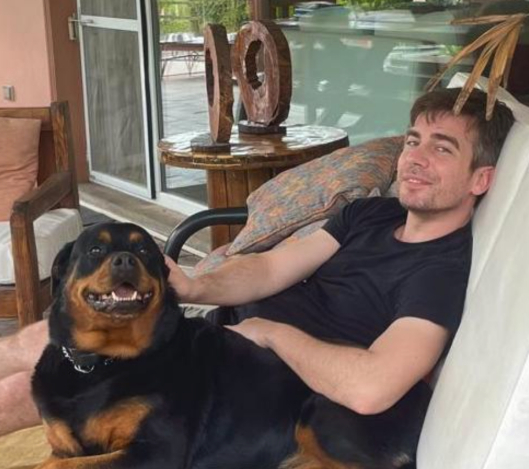 Frank relaxing on a patio with his dog.